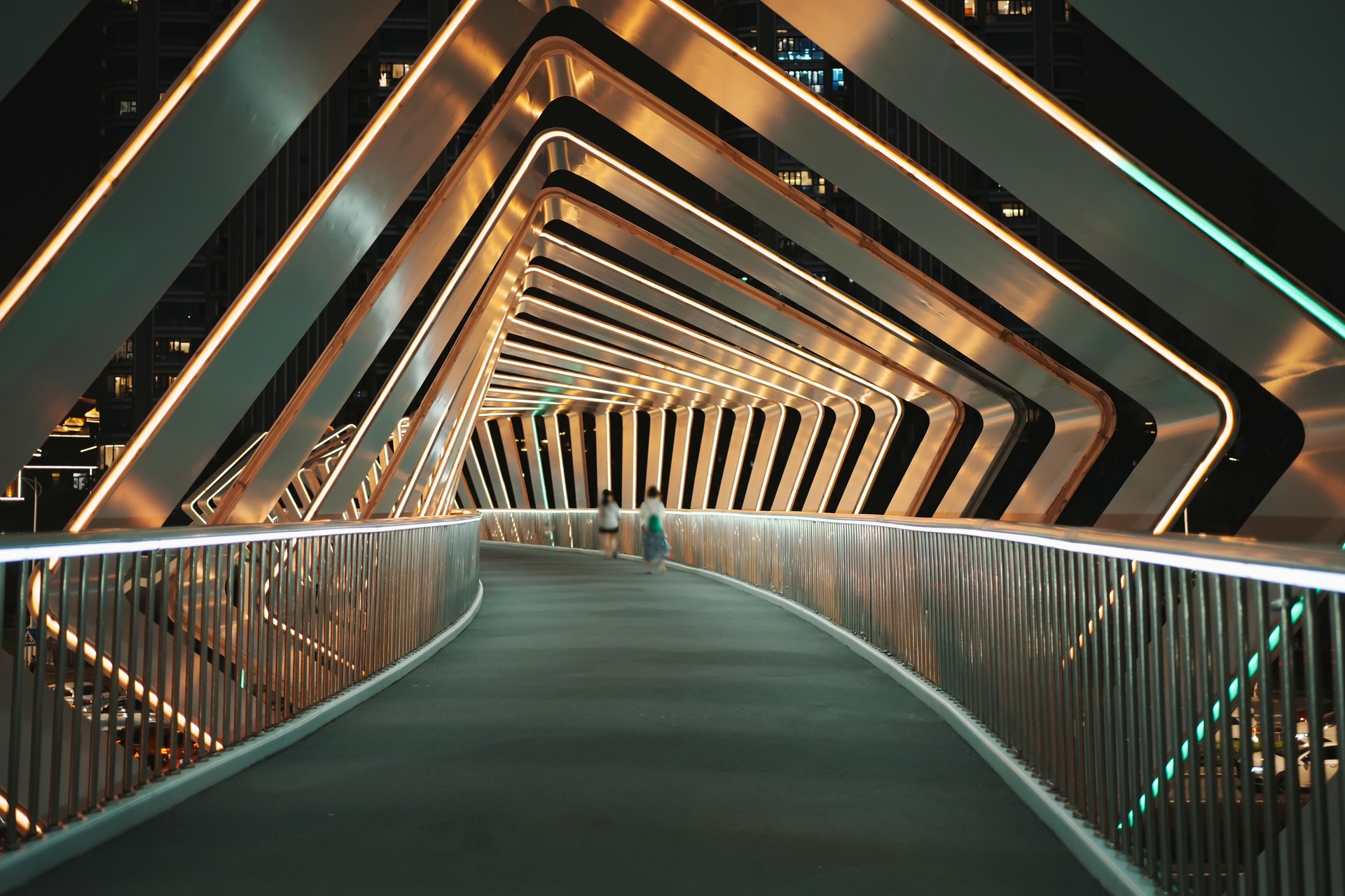 Des piétons marchent sur une passerelle piétonne moderne